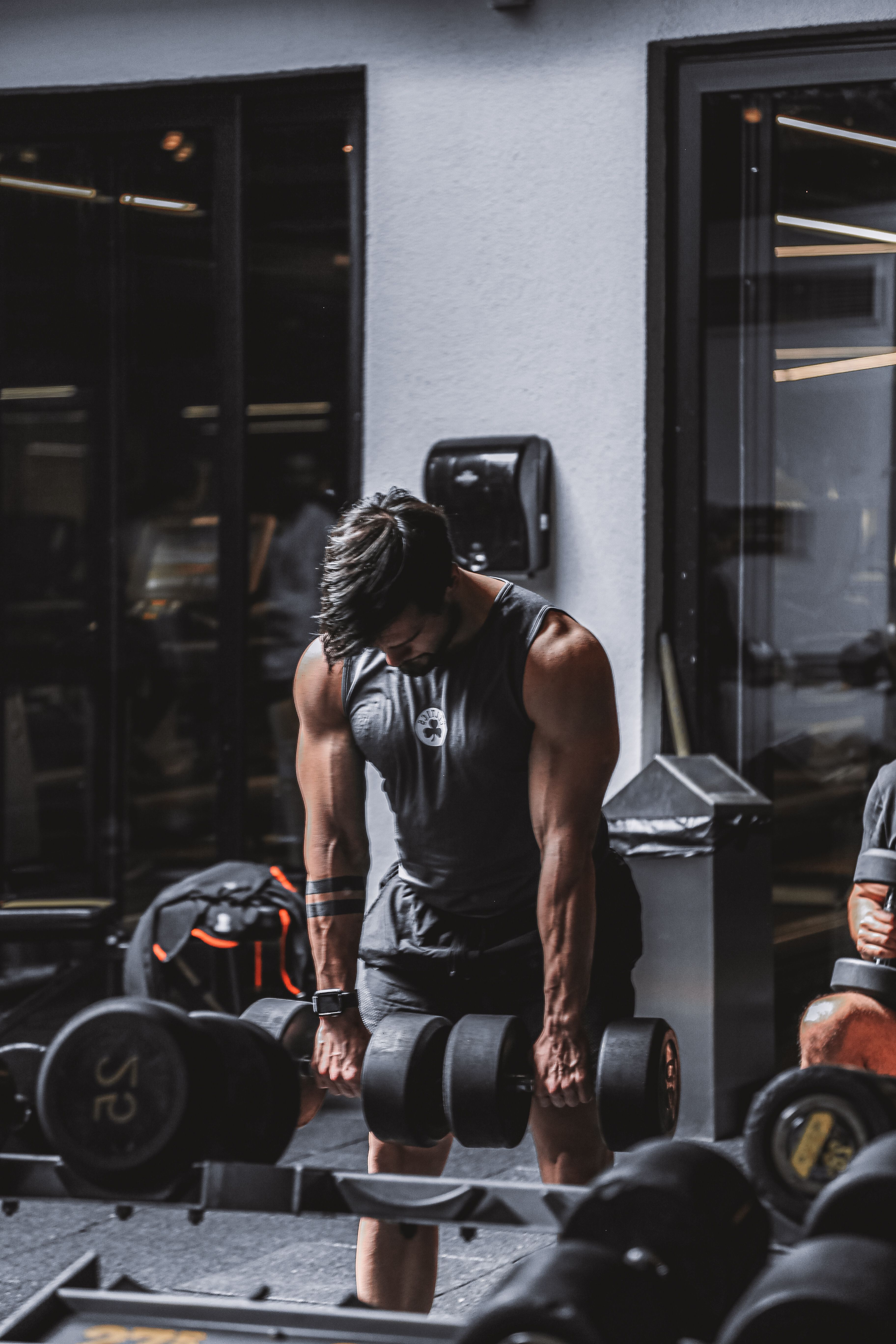 A lifter mid-set in a gym, deadlifting under low, dramatic light